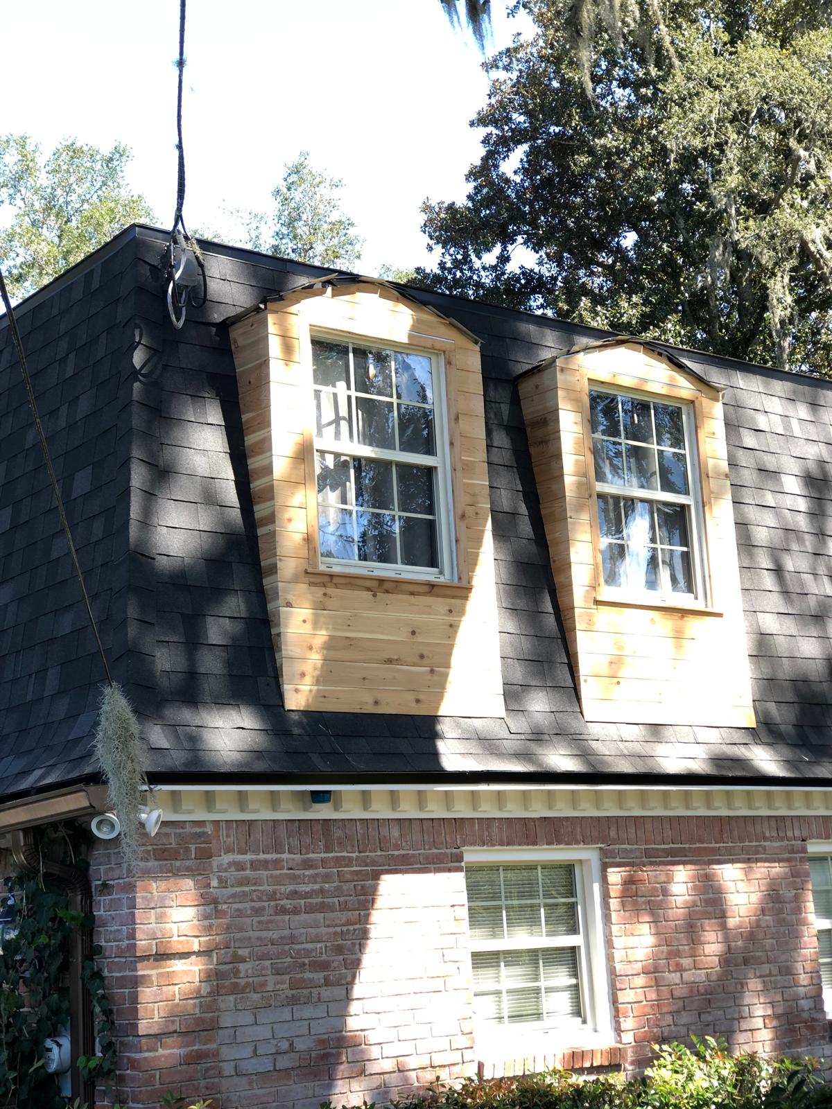 Finished exterior dormers with new natural wood cladding around windows