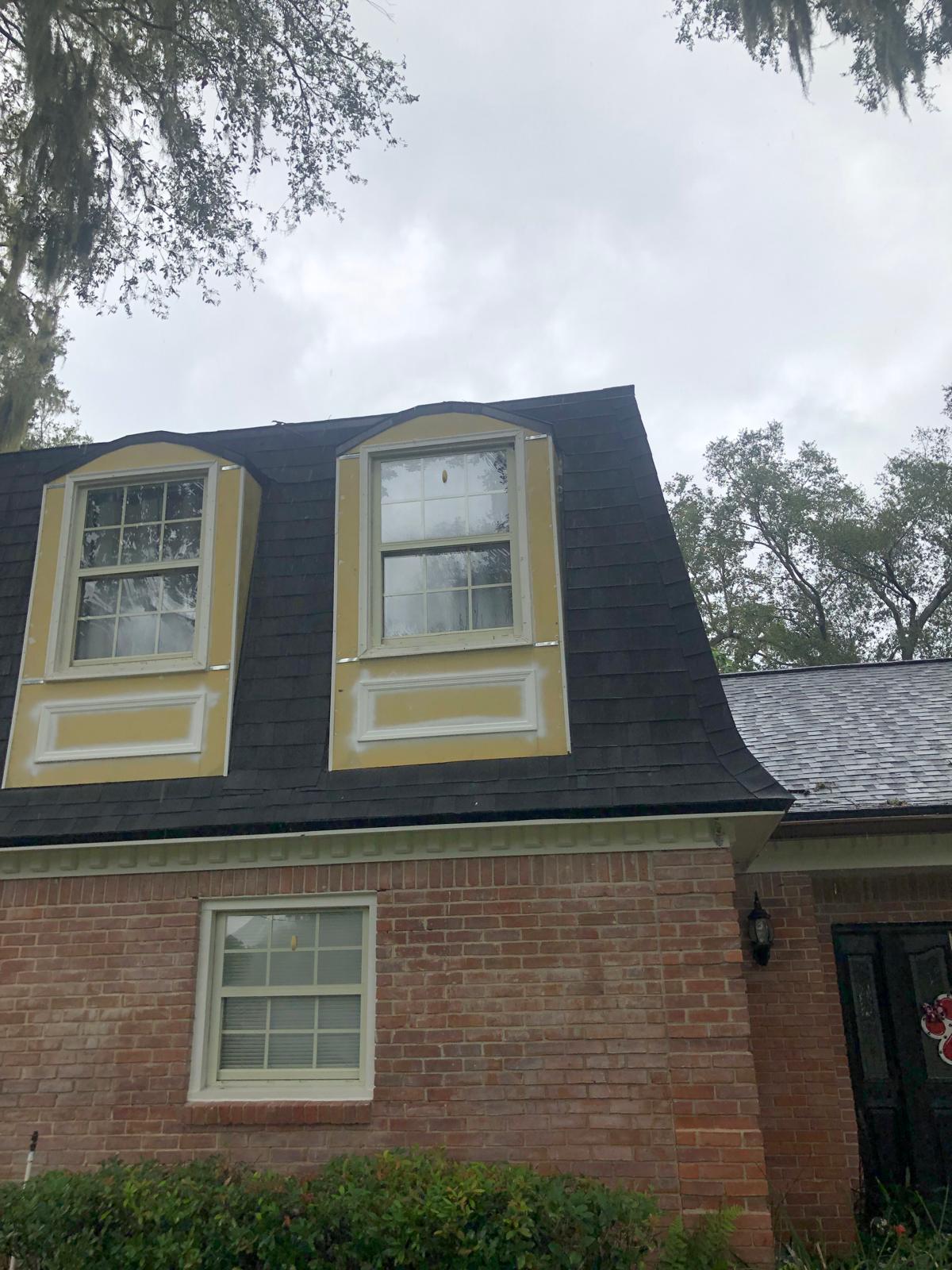 Exterior dormers before with repair areas visible on upper roofline